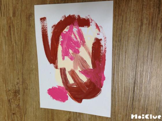 画用紙に絵の具で色を乗せている写真