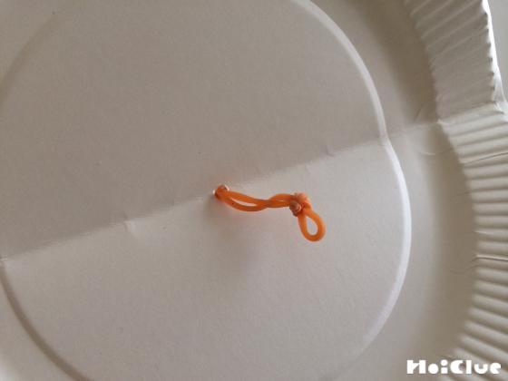 紙皿の穴に輪ゴムを通し玉結びした写真