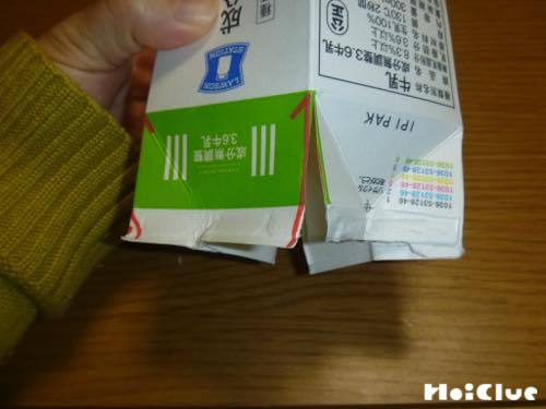 飲み口を開いた牛乳パックの4角に縦に切り込みを入れた写真