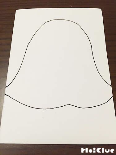 折ったコピー用紙におばけの絵を描く様子