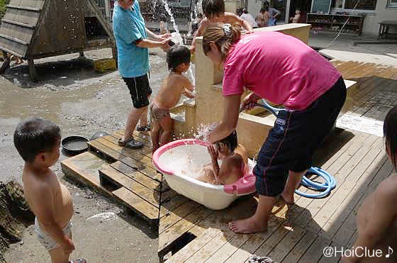 先生と一緒に水遊びをする子どもたちの様子