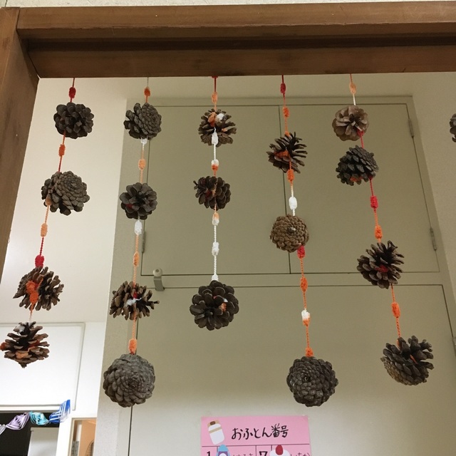 【みんなの投稿】松ぼっくりに毛糸を巻きつけて、のれん♪