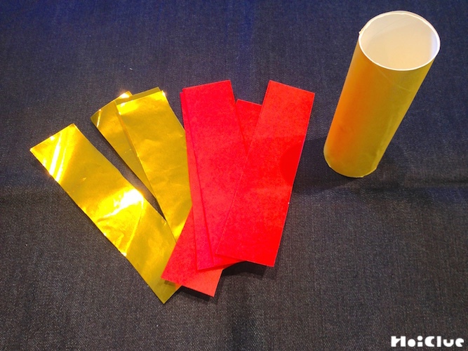 トイレットペーパーの芯と縦4等分に切った折り紙の写真