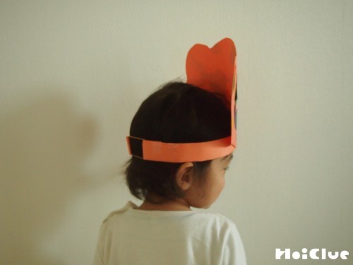 完成したおばけかぼちゃの冠をかぶる子どもの写真