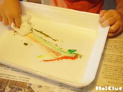 丸めた花紙に絵の具をつける子どもの様子